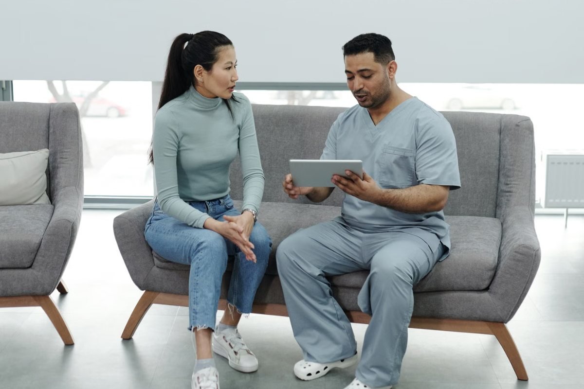 A patient and a clinician looking at a tablet together during a consultation